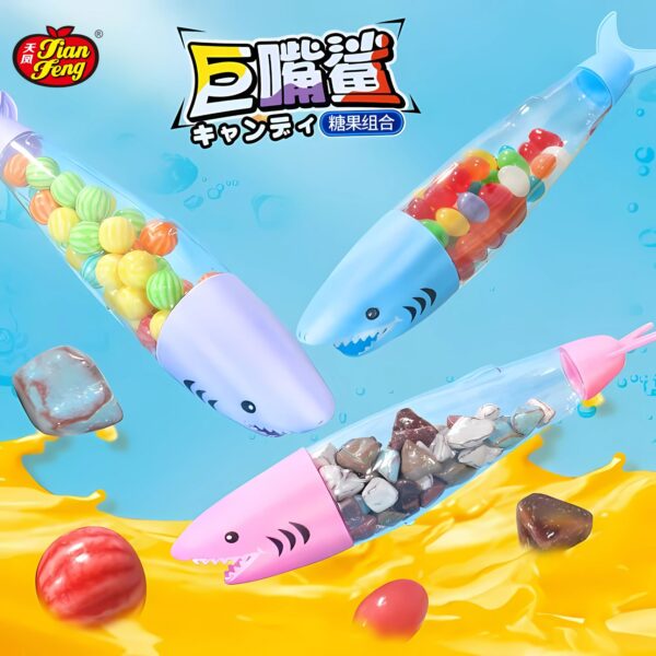 Colorful shark-shaped candy toy containers filled with assorted sweets (jelly beans, bubble gum & stone chocolate candy ) are floating in a splash of yellow liquid. The candy toy containers are light blue, pink, and blue with matching shark fin caps.